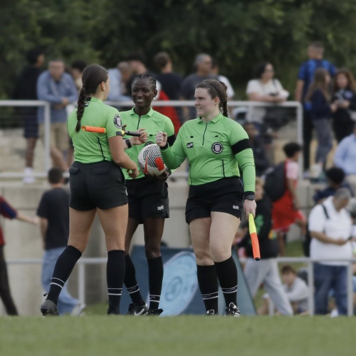 Referees shaking hands on the field after a match