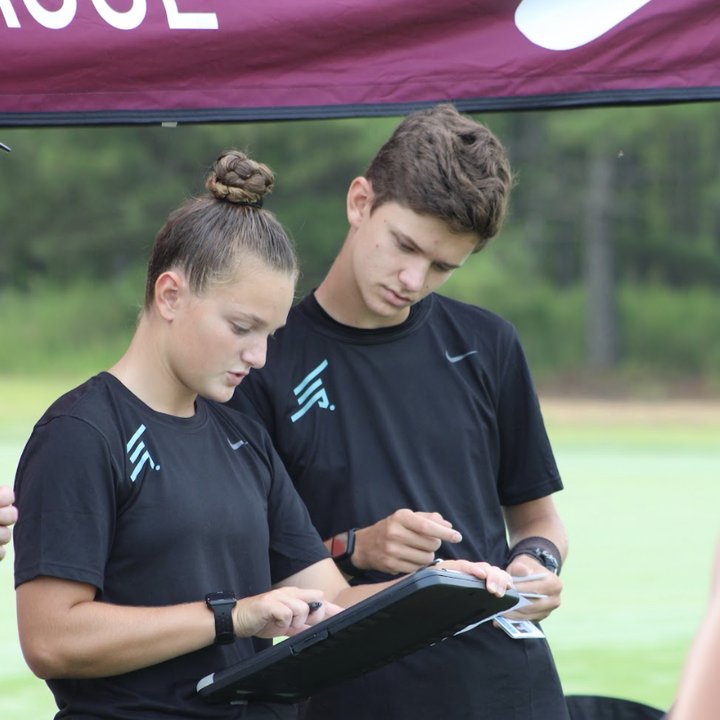 Two referees reviewing notes on a clipboard